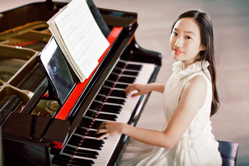 East asian teenage girl playing piano